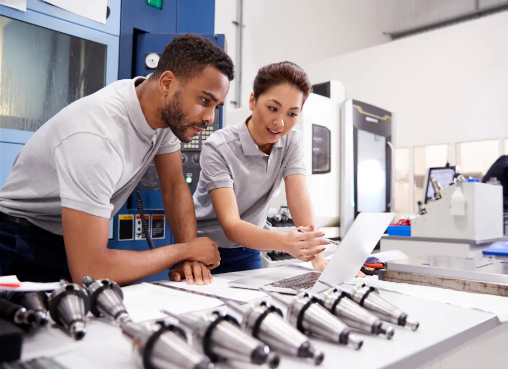 Manufacturing team reviewing plans at a workstation