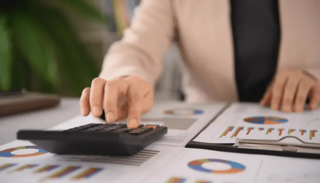 Professional reviewing financial charts with a calculator